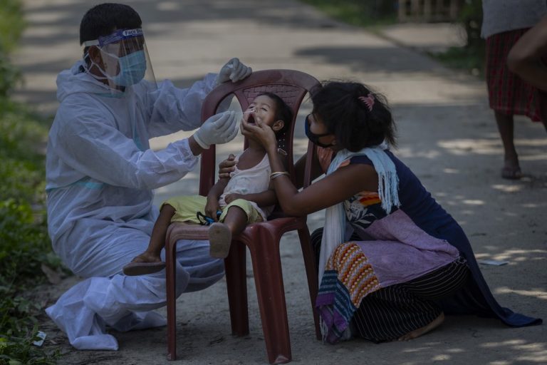 Trabalhador de saúde indiano coleta swab nasal de criança para teste de Covid-19 na vila de Burha Mayong, distrito de Morigaon, estado de Assam, na Índia, em 22 de maio de 2021 — Foto: Anupam Nath/AP