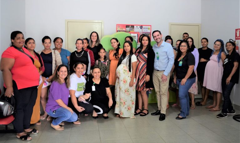 Esta imagem contém, dois homens e várias mulheres posando para a foto lado a lado e algumas abaixadas. Entre essas pessoas estão mulheres gestantes no HCN, violência obstétrica, parto humanizado