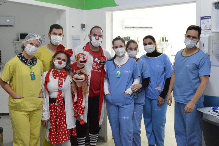 Equipe e colaboradores do Hetrin posam para uma foto lado a lado, com o grupo voluntário Missão Sorrisos que são palhaços com fantoches.